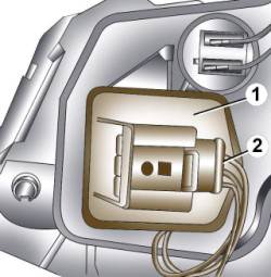 Расположение электрического разъема (2) двигателя корректора фар (1)